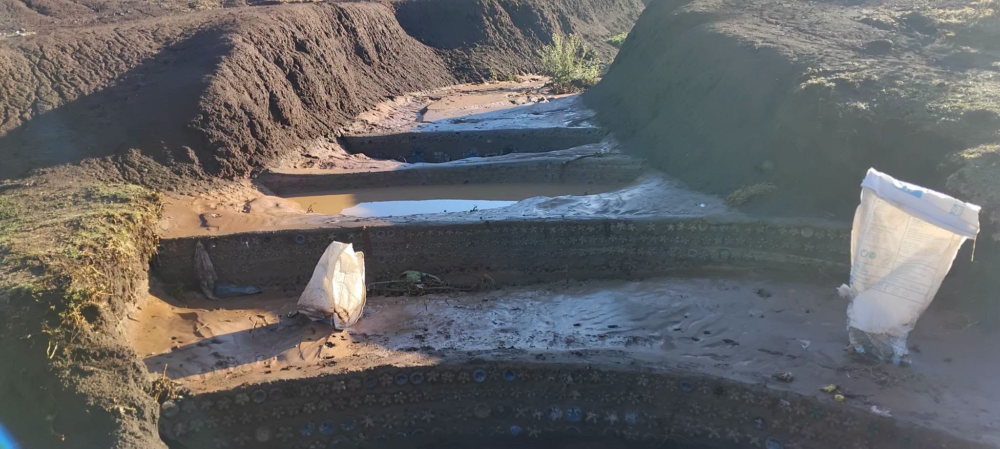 Stone gabion drainage structure under construction